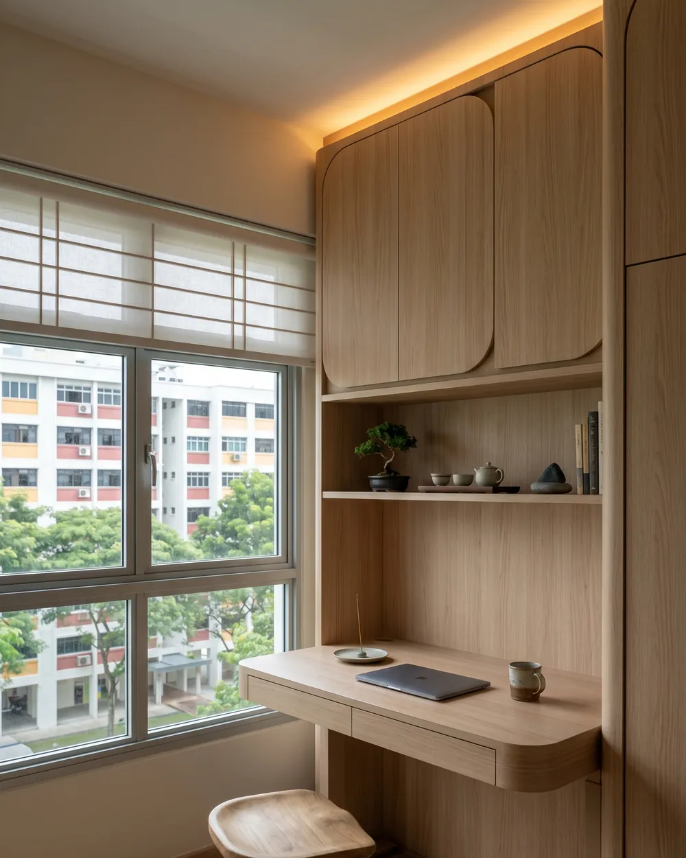 Study nook in a completed HDB flat: a slim oak desk built in under shelving, beside a window looking out to the block opposite